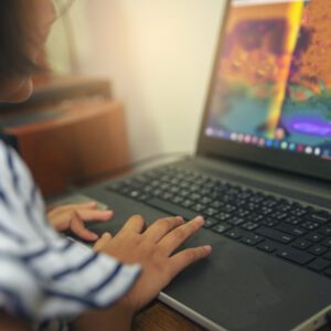Maipú se subió al tren de desarrollo de videojuegos Asian kid typing laptop in computer classroom at primary school.