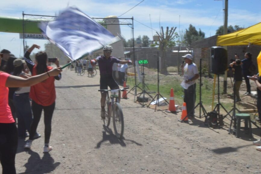 Ciclista cruzando la meta del Rural Bike con la bandera a cuadros