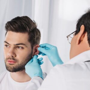 Eccema ótico, o picor de oído doctor examining male patient ear