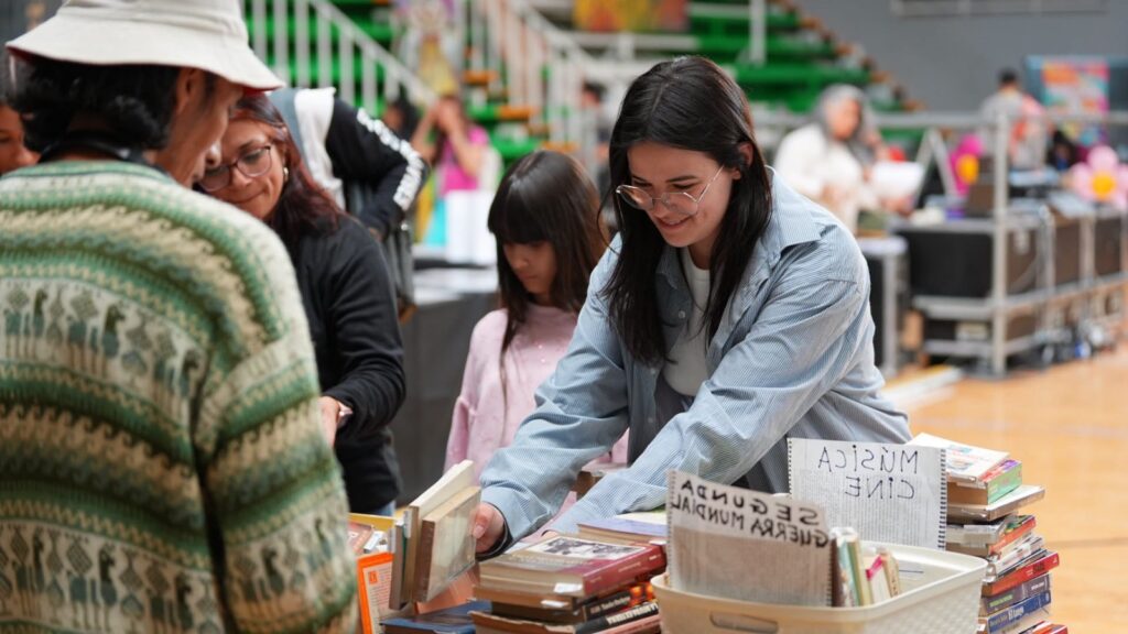 Visitantes en un puesto de libros