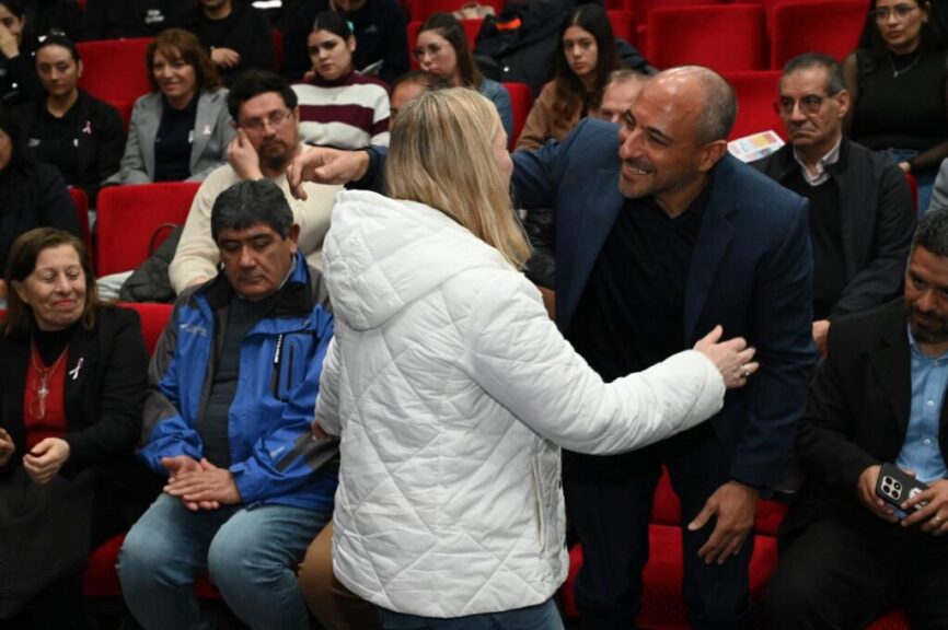 Saludo entre asistentes en la sala