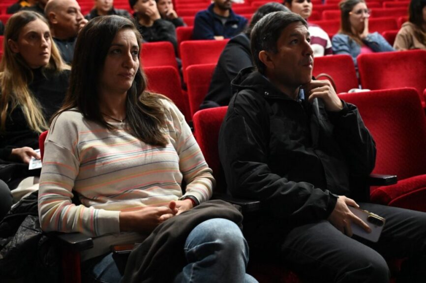 Asistentes siguen las exposiciones en la sala