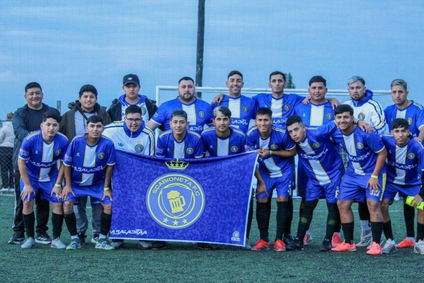 Un equipo posa con su bandera antes de jugar