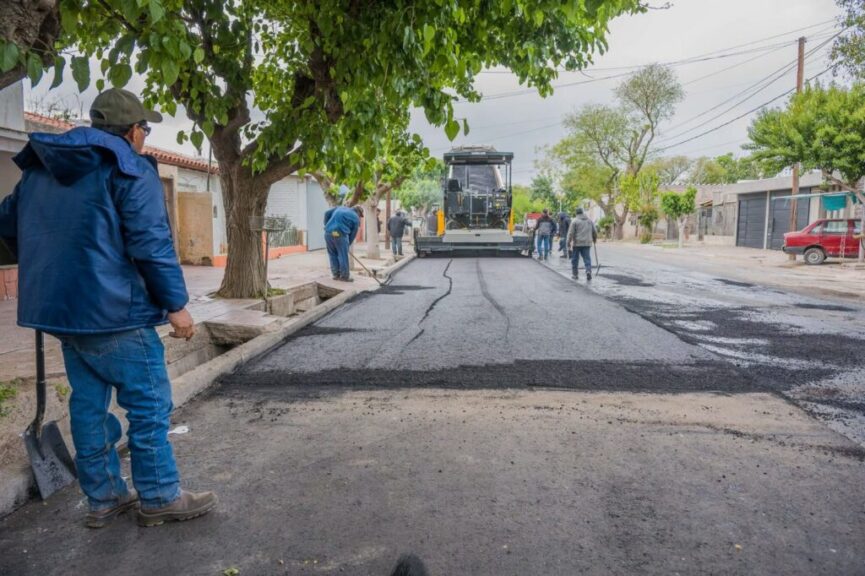 Operarios junto a la terminadora de asfalto en barrio Córdoba