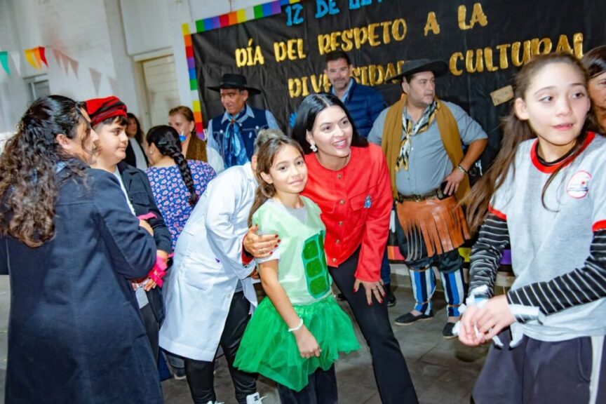 Una niña con disfraz saluda durante el acto