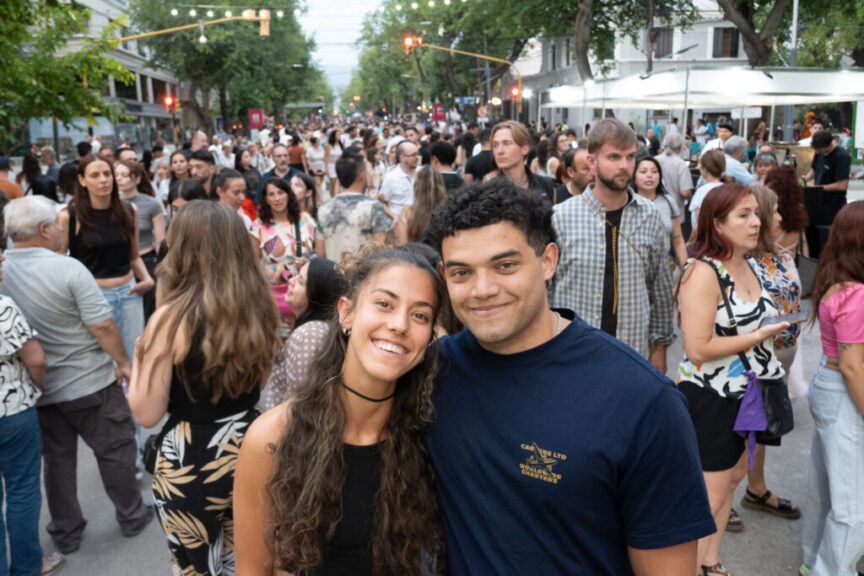 Una pareja posa sonriente entre la multitud en calle Sarmiento